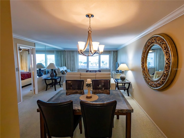 dining room with crown molding, a chandelier, and carpet floors