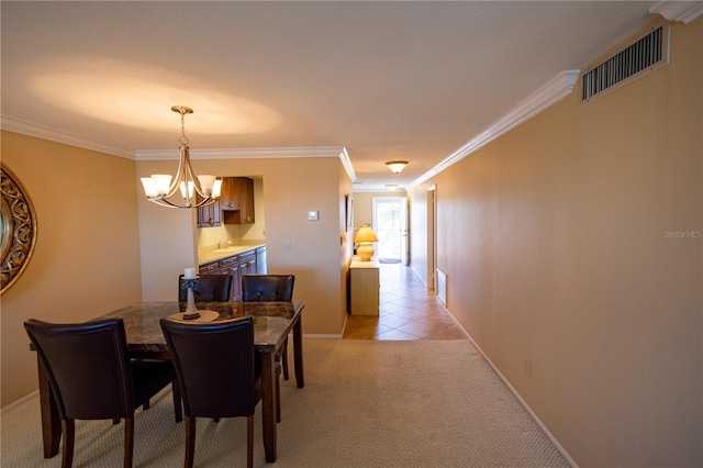 dining area with crown molding, a notable chandelier, and light tile patterned floors