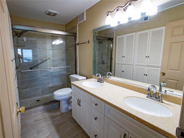 bathroom with vanity, an enclosed shower, and toilet