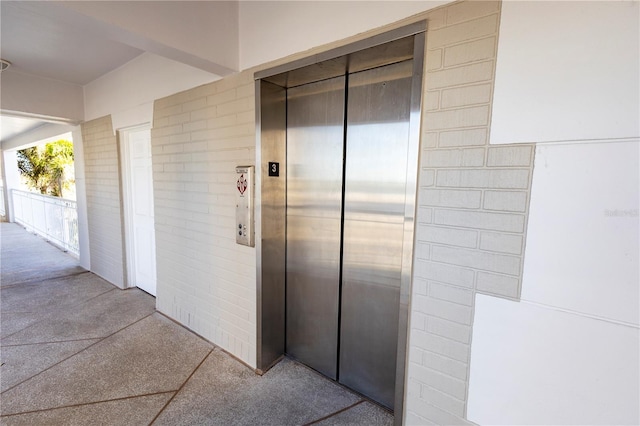 hallway with light carpet and elevator