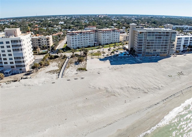 birds eye view of property with a water view and a beach view