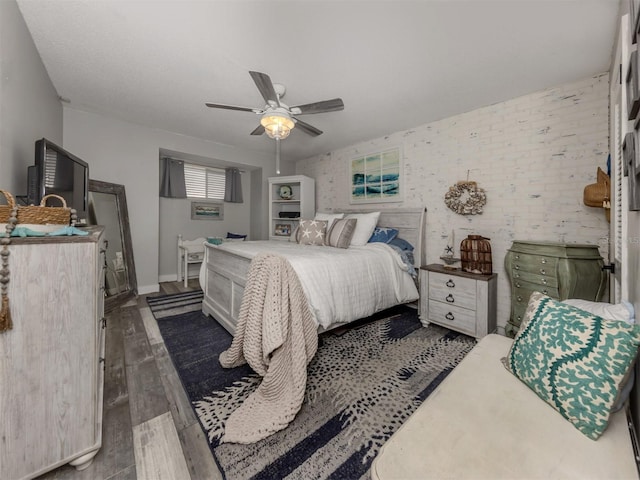 bedroom featuring baseboards, wood finished floors, and a ceiling fan