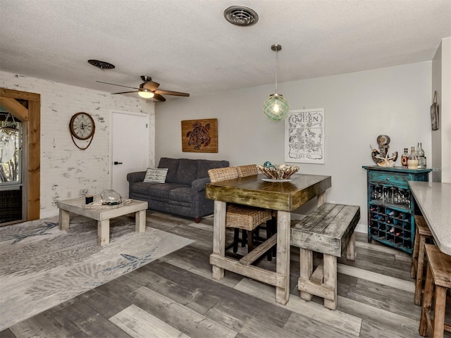 interior space featuring visible vents, a textured ceiling, and wood finished floors