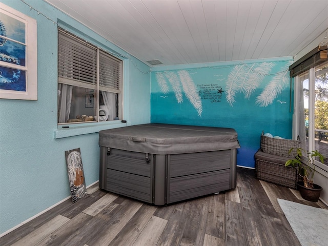 bedroom with wooden ceiling, baseboards, and wood finished floors