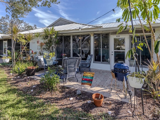 rear view of house with metal roof and a patio area