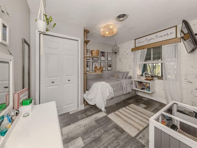 335 Englewood Isles Parkway Unit 55, Englewood, FL 34223 - bedroom featuring dark wood-type flooring, a closet, and a textured ceiling