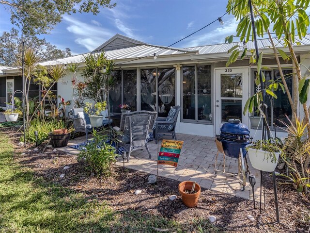 335 Englewood Isles Parkway Unit 55, Englewood, FL 34223 - rear view of house with a patio area, a sunroom, and metal roof