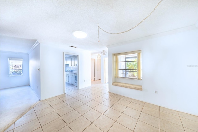 unfurnished room with crown molding, a textured ceiling, and light tile patterned floors