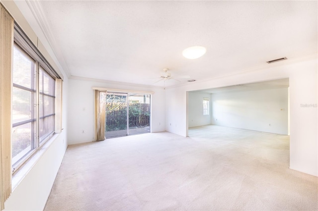 spare room with ornamental molding, light colored carpet, and ceiling fan