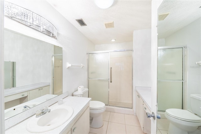 bathroom with vanity, tile patterned flooring, a shower with shower door, and toilet