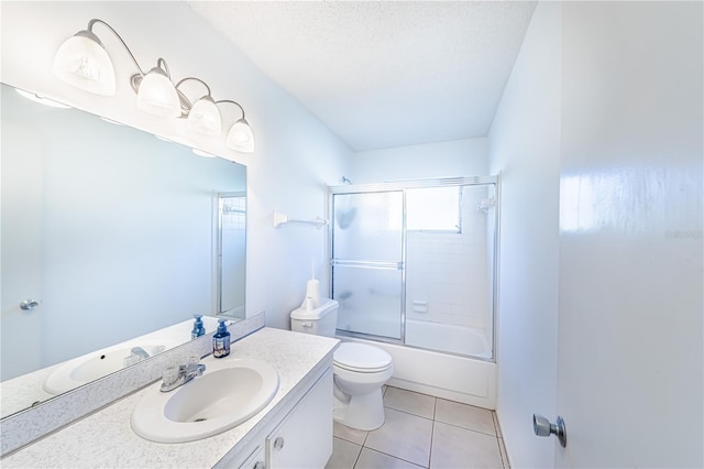 full bathroom with shower / bath combination with glass door, vanity, toilet, tile patterned floors, and a textured ceiling