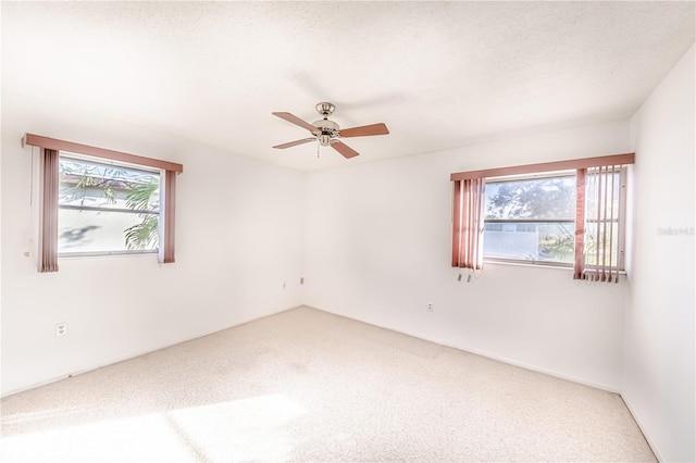 carpeted spare room featuring ceiling fan and a textured ceiling