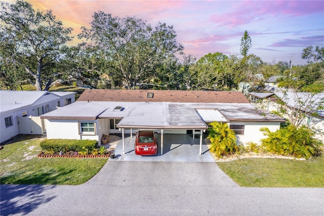 view of front of house with a carport and a lawn