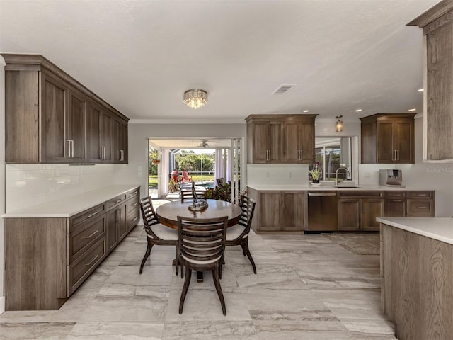 dining space with sink and crown molding