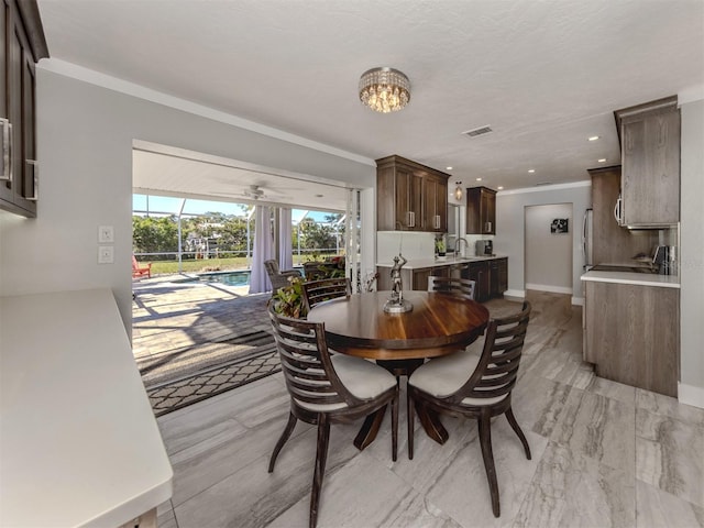 dining room featuring sink and ornamental molding