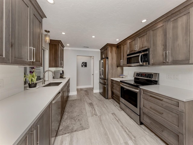 kitchen with sink, decorative backsplash, stainless steel appliances, crown molding, and light hardwood / wood-style flooring