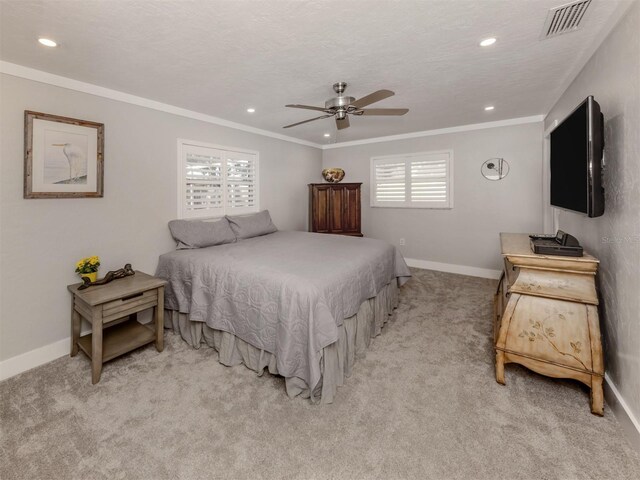 bedroom with ceiling fan, ornamental molding, light carpet, and a textured ceiling