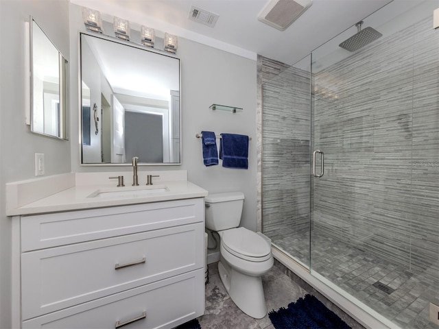 bathroom featuring vanity, a shower with shower door, and toilet