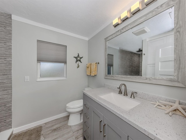 bathroom with vanity, hardwood / wood-style floors, ornamental molding, and toilet