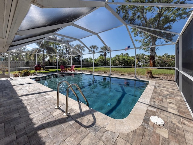 view of swimming pool featuring a yard, a patio area, and glass enclosure