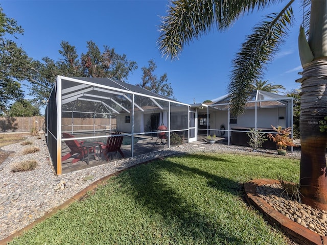 exterior space with a yard, a patio area, and glass enclosure