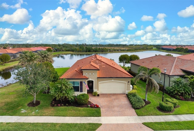 mediterranean / spanish-style house with a water view, a garage, and a front lawn