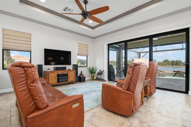 living room featuring a raised ceiling, crown molding, light tile patterned flooring, and ceiling fan