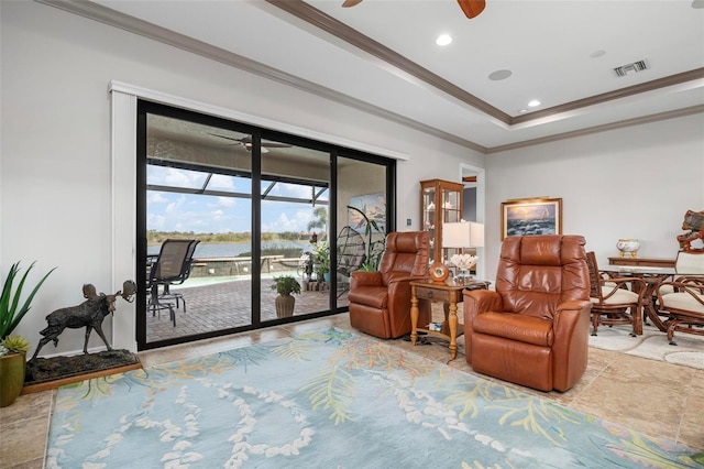 living area featuring a tray ceiling, crown molding, and ceiling fan