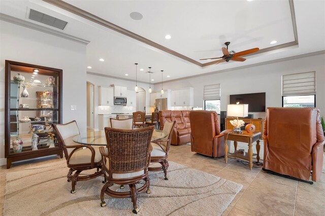 dining room featuring ceiling fan, ornamental molding, and a raised ceiling