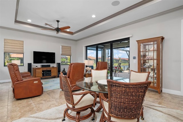 dining area with crown molding, ceiling fan, and a raised ceiling