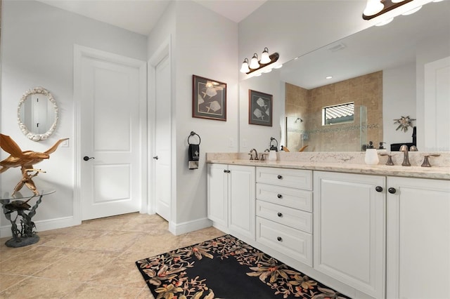 bathroom with a tile shower and vanity