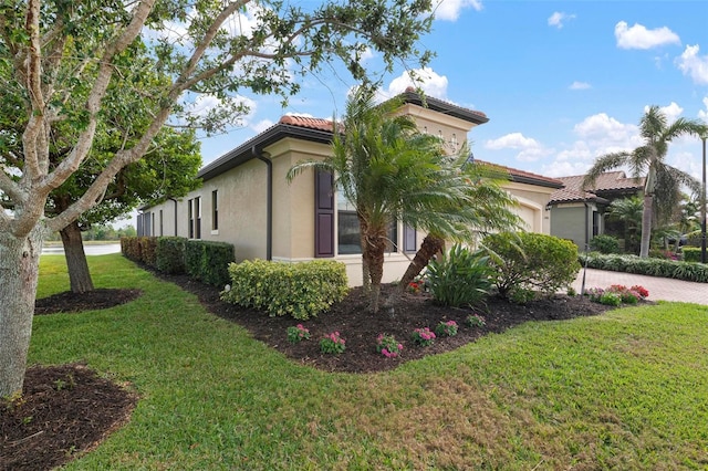 view of side of home featuring a garage and a yard