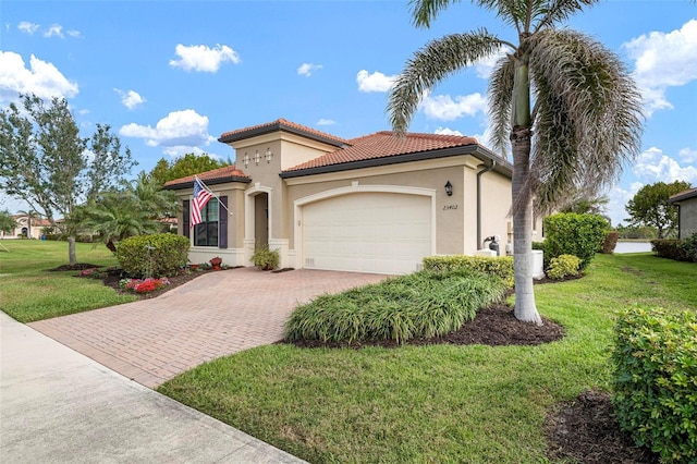 mediterranean / spanish house with a garage and a front lawn