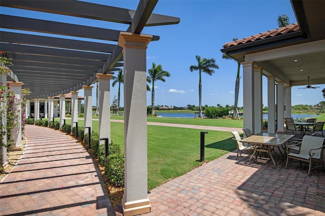 view of patio / terrace with a water view, ceiling fan, and a pergola