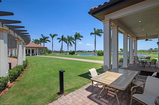 view of patio with a water view and ceiling fan