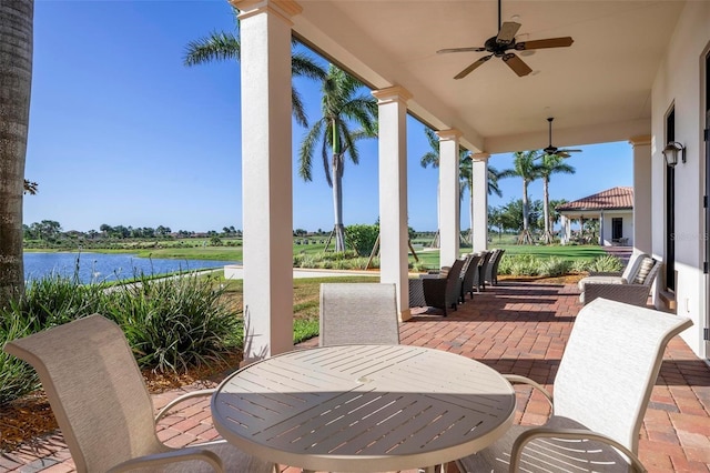 view of patio featuring a water view and ceiling fan