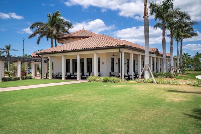 rear view of property with a yard and ceiling fan