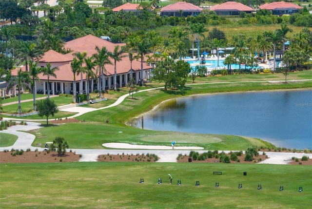 surrounding community featuring a water view and a lawn