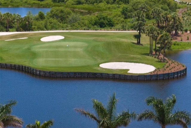 surrounding community with a water view and a lawn