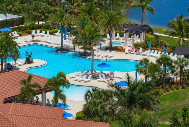 view of swimming pool featuring a hot tub, a water view, a patio area, and a pergola