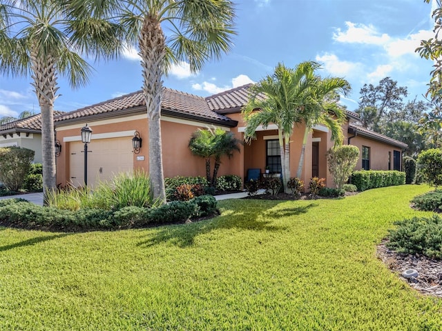 mediterranean / spanish home with a garage and a front lawn