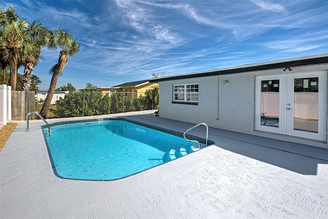 view of swimming pool with french doors and a patio