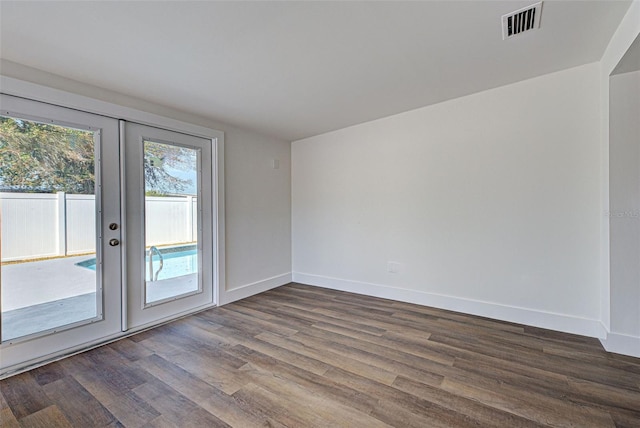 spare room featuring dark wood-type flooring and french doors