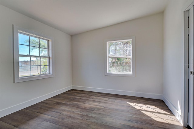 unfurnished room featuring plenty of natural light and dark hardwood / wood-style floors