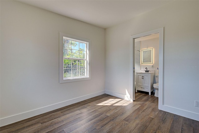 unfurnished bedroom with dark hardwood / wood-style floors and ensuite bathroom