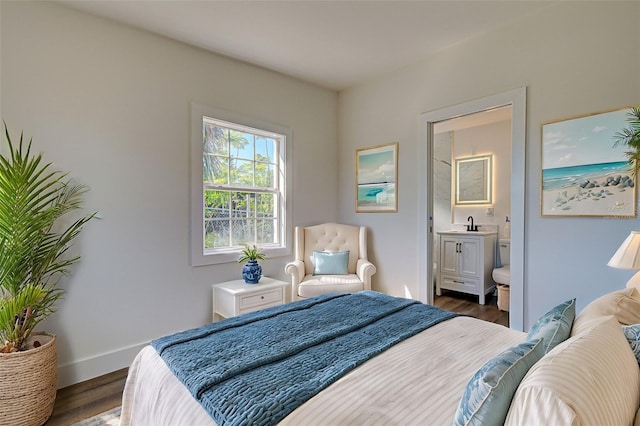 bedroom featuring ensuite bath and dark hardwood / wood-style floors