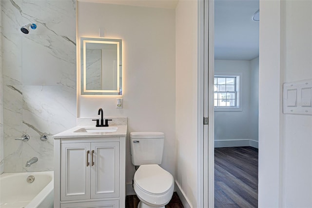 full bathroom with vanity, toilet, tiled shower / bath combo, and hardwood / wood-style floors