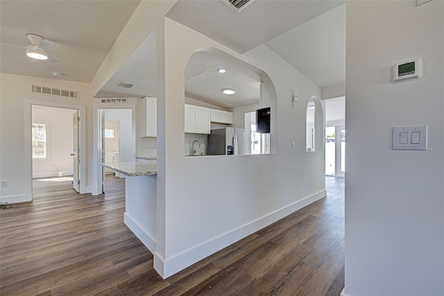 corridor featuring a healthy amount of sunlight, dark hardwood / wood-style floors, and sink