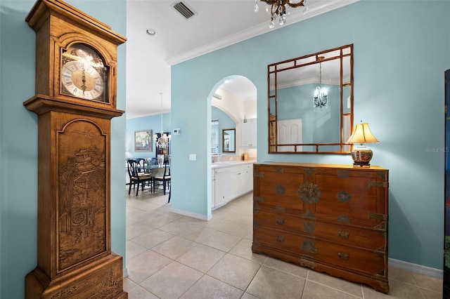 corridor featuring crown molding, sink, light tile patterned floors, and a notable chandelier