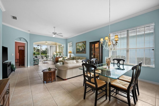 dining space with crown molding, ceiling fan with notable chandelier, and light tile patterned floors